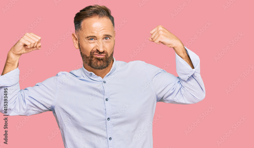 Handsome middle age man wearing business shirt showing arms muscles smiling proud. fitness concept. Handsome middle age man wearing business shirt showing arms muscles smiling proud. fitness concept.