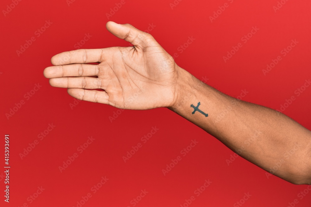 Hand of hispanic man over red isolated background stretching and reaching with open hand for handshake, showing palm Hand of hispanic man over red isolated background stretching and reaching with open hand for handshake, showing palm