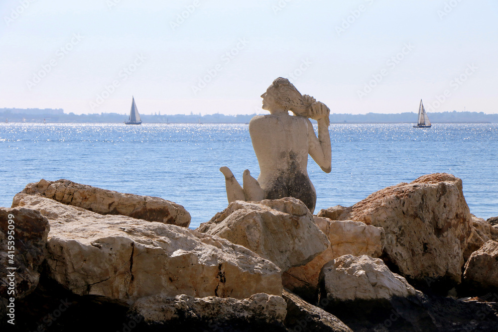 Mermaid on the rocks in the Great Sea of Taranto, the Gulf of Taranto, the Ionian Sea. Puglia, Italy