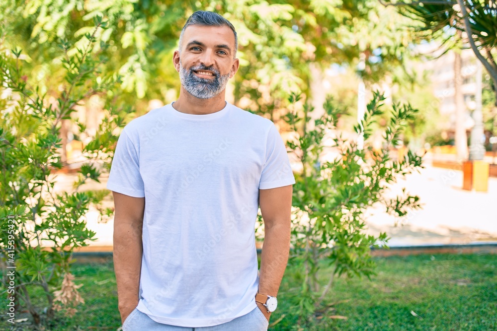 Middle age grey-haired man smiling happy standing at the park. Middle age grey-haired man smiling happy standing at the park.