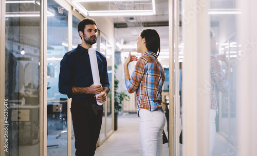 Colleagues having small discussion of new project in office corridor