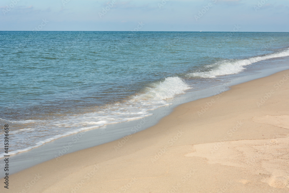 Soft wave with white foam.  Sea surf on sandy beach. Natural background for summer vacation