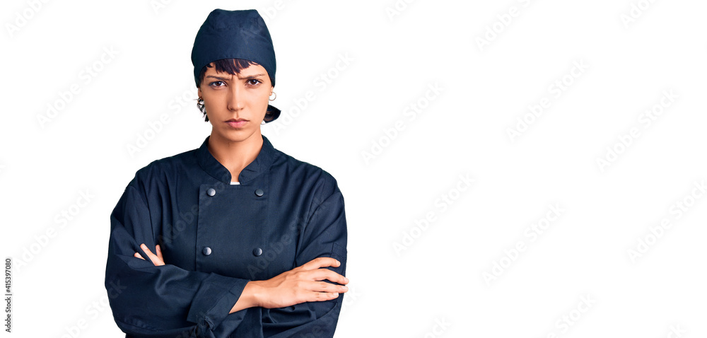 Young brunette woman with short hair wearing professional cook uniform skeptic and nervous, disapproving expression on face with crossed arms. negative person. Young brunette woman with short hair wearing professional cook uniform skeptic and nervous, disapproving expression on face with crossed arms. negative person.