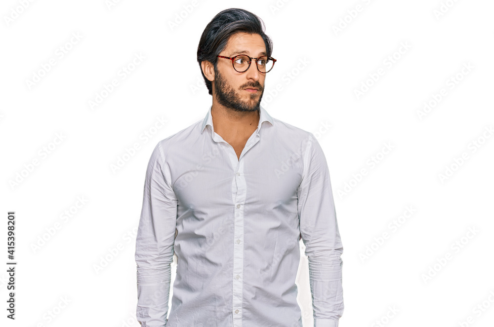 Young hispanic man wearing business shirt and glasses smiling looking to the side and staring away thinking. Young hispanic man wearing business shirt and glasses smiling looking to the side and staring away thinking.