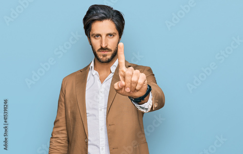 Young hispanic man wearing business clothes pointing with finger up and angry expression, showing no gesture