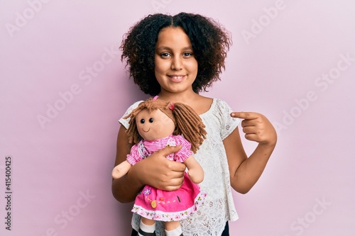 Papier peint Young little girl with afro hair holding animal doll toy smiling happy pointing