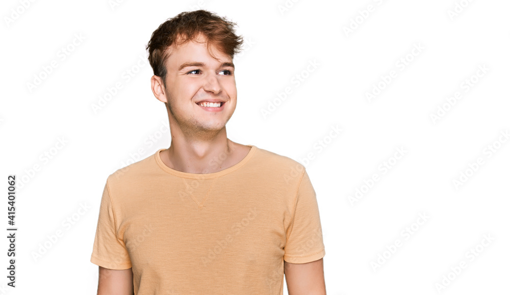 Fototapeta premium Young caucasian man wearing casual clothes looking away to side with smile on face, natural expression. laughing confident.