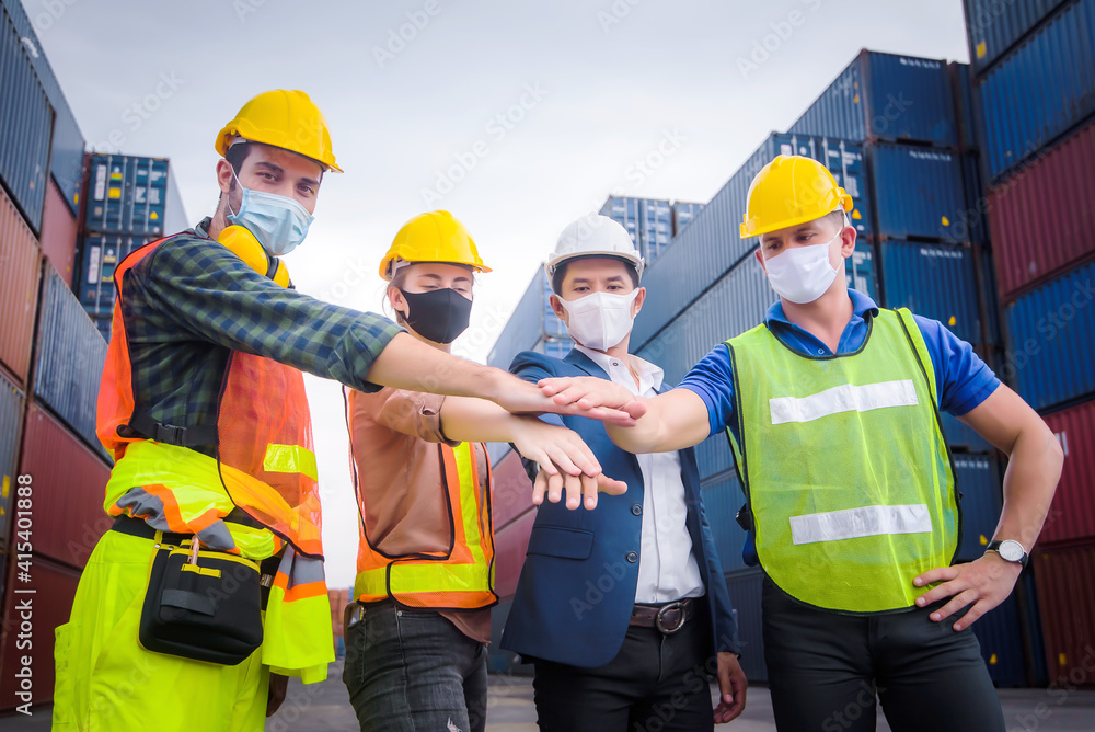 Engineer team people standing with their hands together at the container yard and check for control loading Containers box from Cargo freight ship for import and export. Team Teamwork Concept Engineer team people standing with their hands together at the container yard and check for control loading Containers box from Cargo freight ship for import and export. Team Teamwork Concept