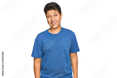 Teenager hispanic boy wearing casual clothes winking looking at the camera with sexy expression, cheerful and happy face. © Krakenimages.com