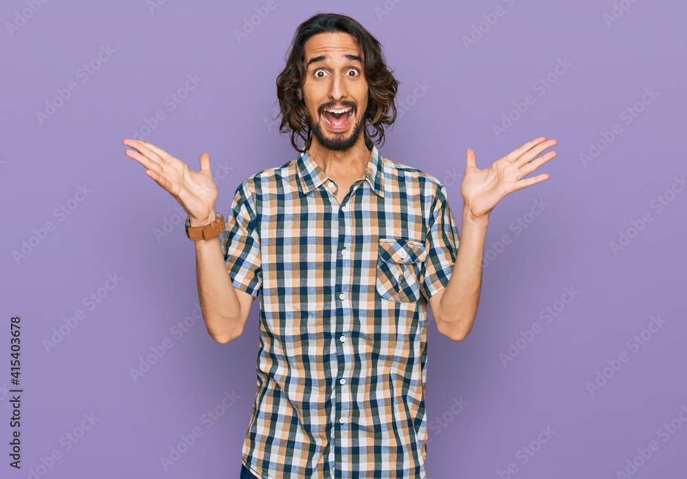 Young hispanic man wearing casual clothes celebrating victory with happy smile and winner expression with raised hands Young hispanic man wearing casual clothes celebrating victory with happy smile and winner expression with raised hands