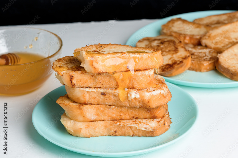 homemade French toast fried with honey on a blue plate on a dark background. soaked in milk egg mixture. healthy breakfast homemade French toast fried with honey on a blue plate on a dark background. soaked in milk egg mixture. healthy breakfast