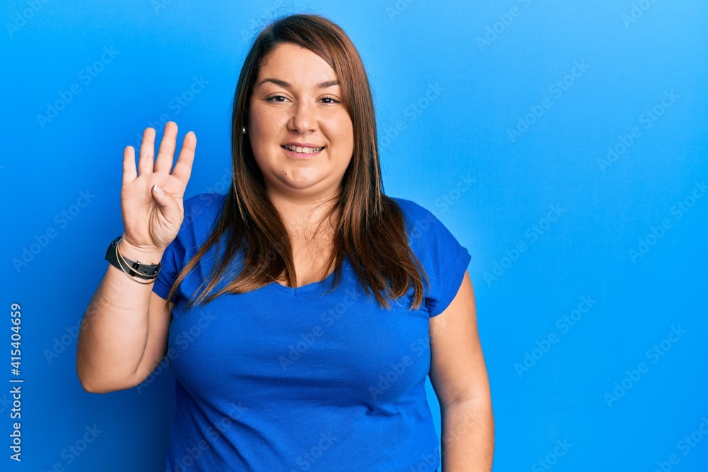Beautiful brunette plus size woman wearing casual blue t shirt showing and pointing up with fingers number four while smiling confident and happy. Beautiful brunette plus size woman wearing casual blue t shirt showing and pointing up with fingers number four while smiling confident and happy.