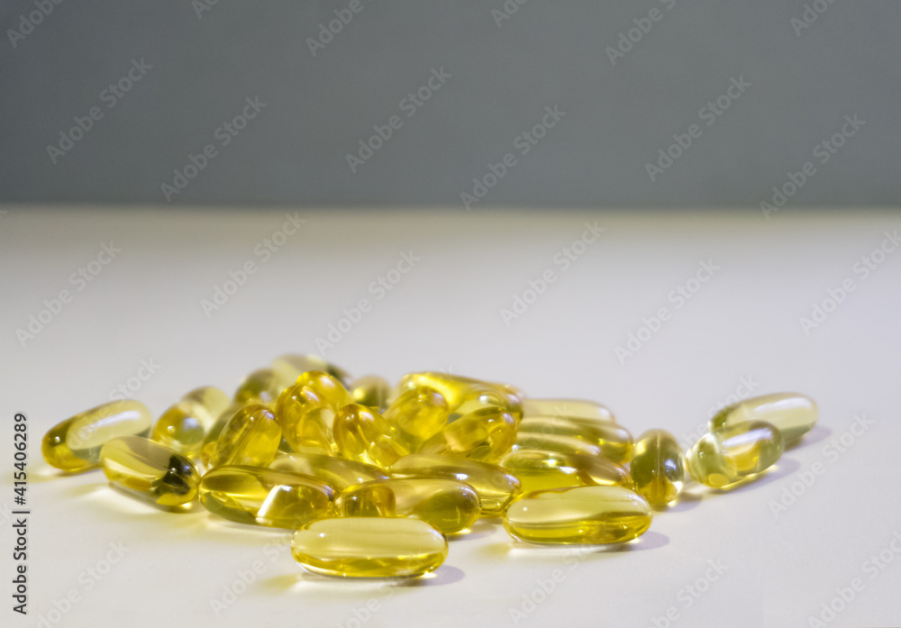 Yellow capsules are scattered on a light background.Soft focus. Yellow capsules are scattered on a light background.Soft focus.