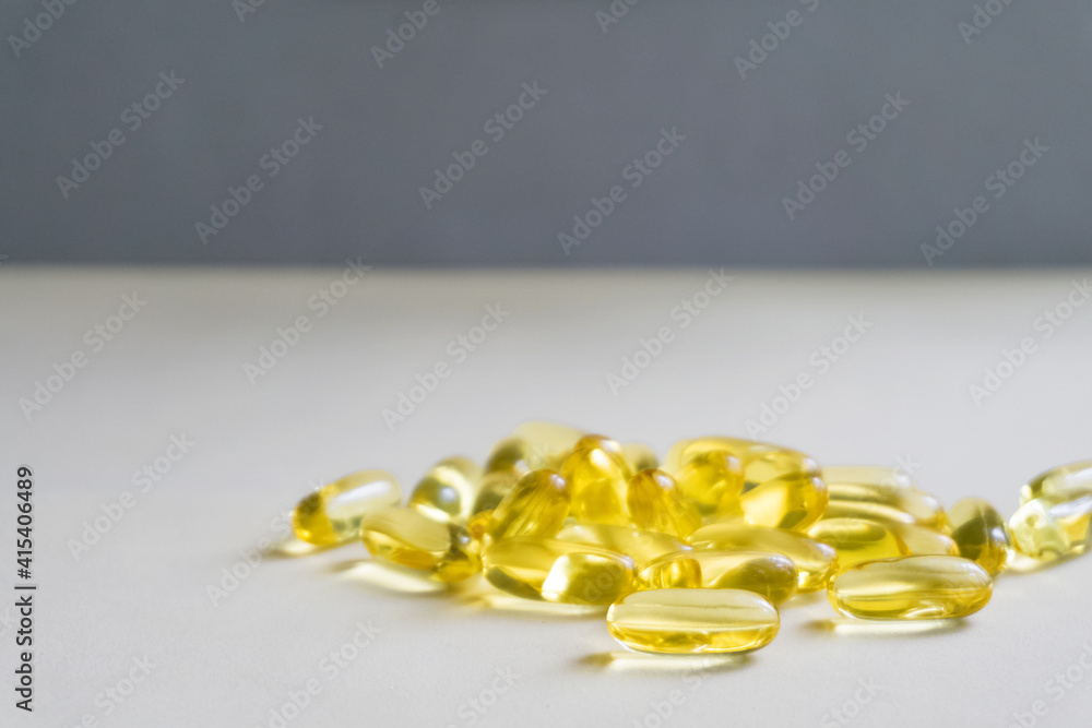 Yellow capsules are scattered on a light background.Soft focus. Yellow capsules are scattered on a light background.Soft focus.