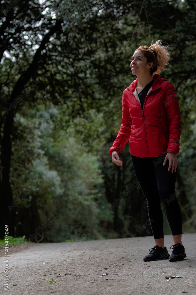 Portrait of a young woman taking a walk in the forest. Young woman doing sport.