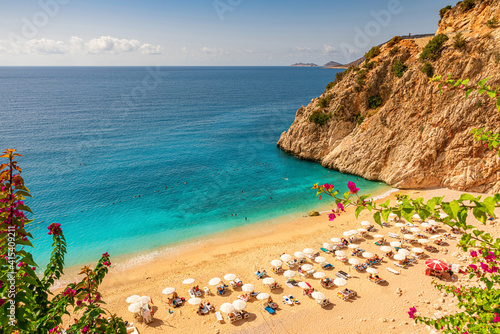 Fototapeta Naklejka Na Ścianę i Meble -  Kaputas beach with blue water on the coast of Antalya region in Turkey with sun umbrellas on the beach
