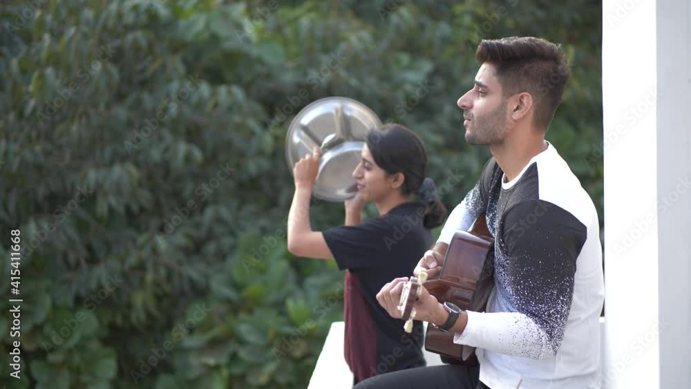 Lovely couple applauding and saluting or showing great reverence for health workers,police,doctors,by banging utensils and playing guitar for them.people taking part in flash mob in lock down period Lovely couple applauding and saluting or showing great reverence for health workers,police,doctors,by banging utensils and playing guitar for them.people taking part in flash mob in lock down period