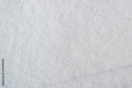 Snow surface texture, sunny winter day outside. Snow background, soft focus. Top view, copy space