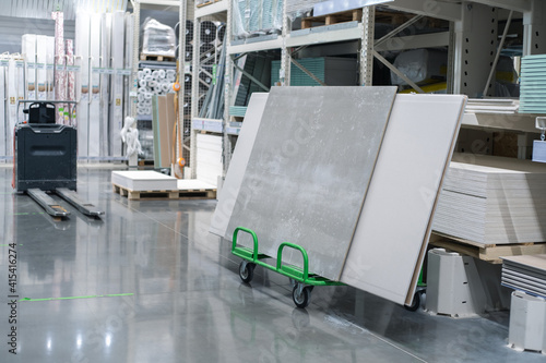 Gypsum panels lie on a cart in a building supplies store. Selective focus. Copy space