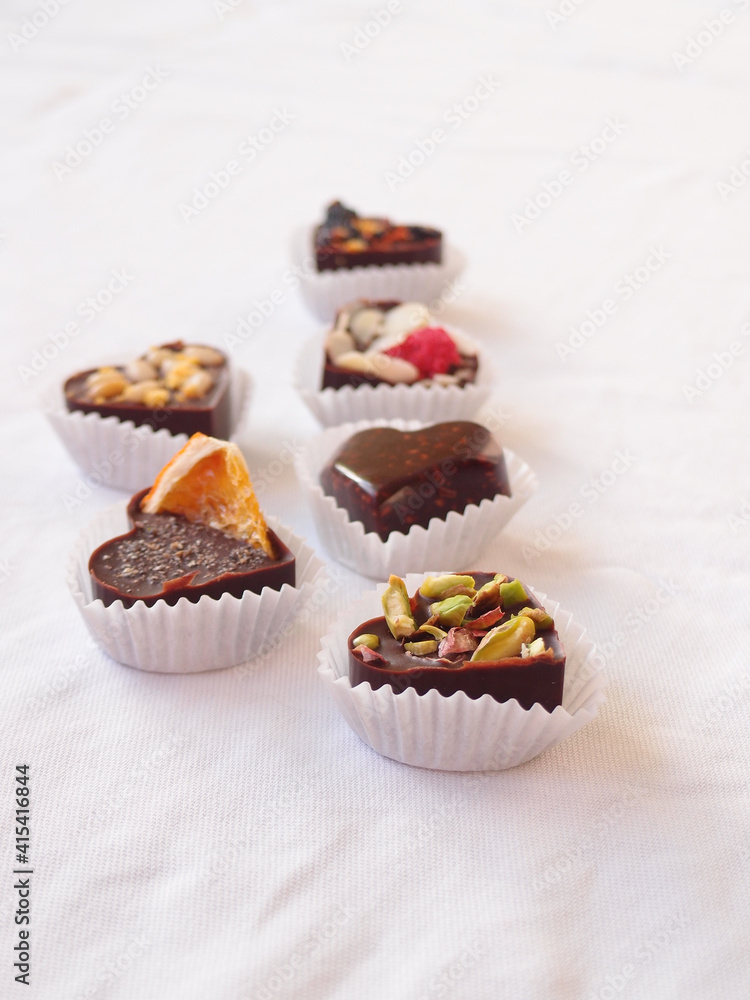 Delicious homemade chocolate with nuts and berries on a white tablecloth. chocolate candies close up