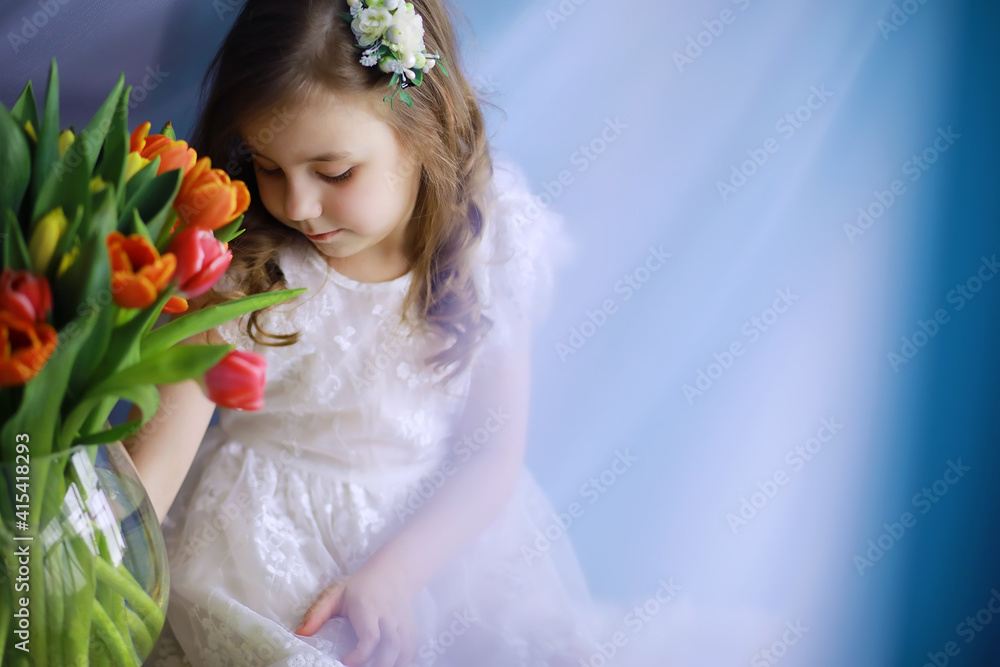 Beautiful girl in white dresses with a magnificent bouquet of the first tulips. International Women's Day. Girl with tulips. Beautiful girl in white dresses with a magnificent bouquet of the first tulips. International Women's Day. Girl with tulips.