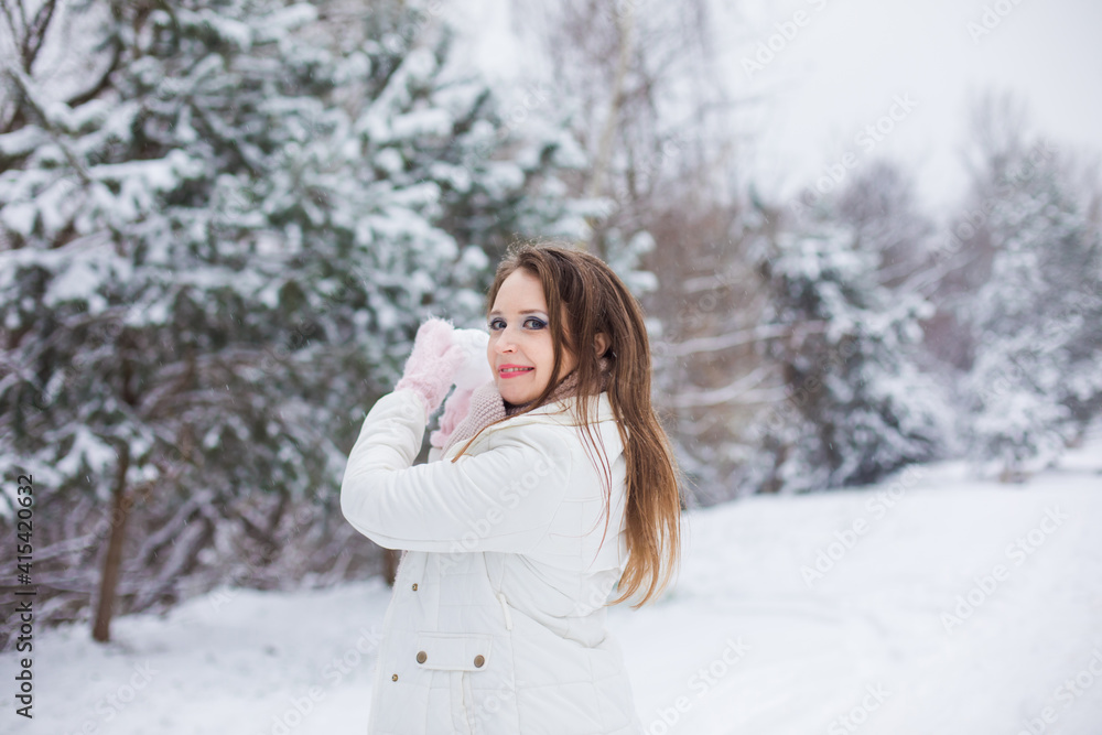 the woman is enjoying while plays snowballs in winter the woman is enjoying while plays snowballs in winter
