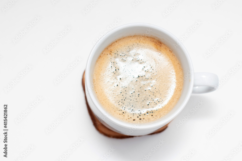 White cup with fresh black americano coffe on circle wooden cut White cup with fresh black americano coffe on circle wooden cut