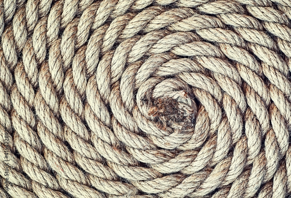 Braided thick rope tied in a skein. Hemp rope for decoration and design. Background from a fishing rope.