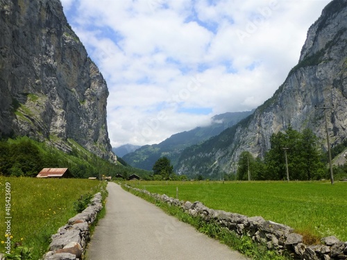 Road leading through the Lauterbrunnen Valley, Switzerland with sheer rock faces rising up on either side © Alistair MacLean
