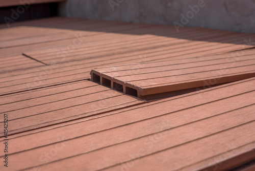 Damaged Plastic Wood boards because of humidity and moisture, bending and come out, image Close-up.