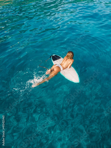Canvas Print Attractive surfer woman relaxing on surfboard in ocean