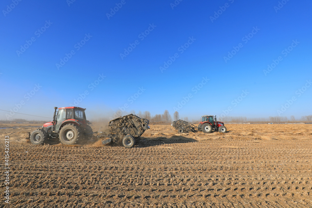 Obraz premium farmers use agricultural machinery to compress rice straw and bundle them on a farm, LUANNAN COUNTY, Hebei Province, China