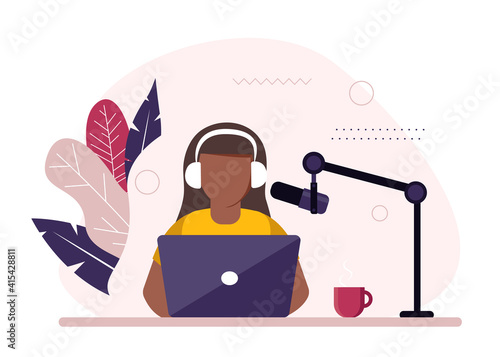 African-american radio host sitting in front of microphone. Young woman in headset working at the radio studio