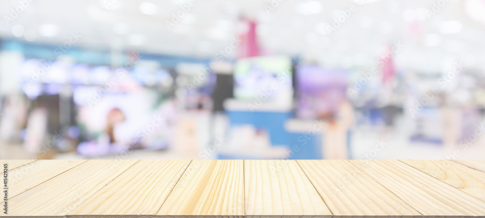 wood table top with blur electronic department store show Television TV and home appliance background for product display