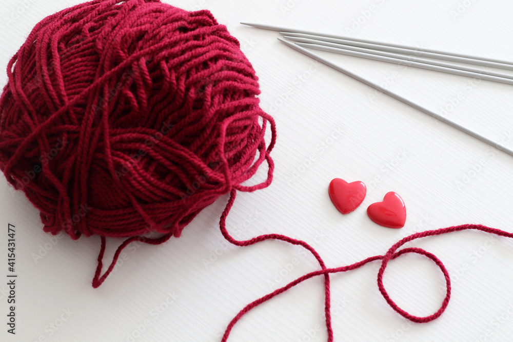 red wool yarn ball with knitting needles and hearts red wool yarn ball with knitting needles and hearts