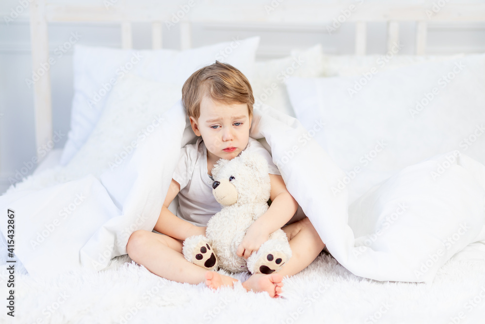 a child is sad with a teddy bear on the bed at home a child is sad with a teddy bear on the bed at home
