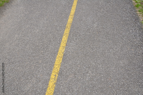 yellow paint line on black asphalt ground