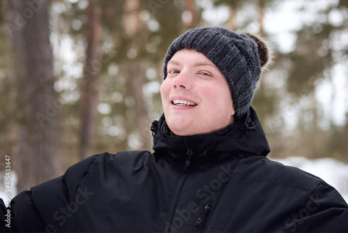 Portrait of a man in a hat and jacket in the winter forest.