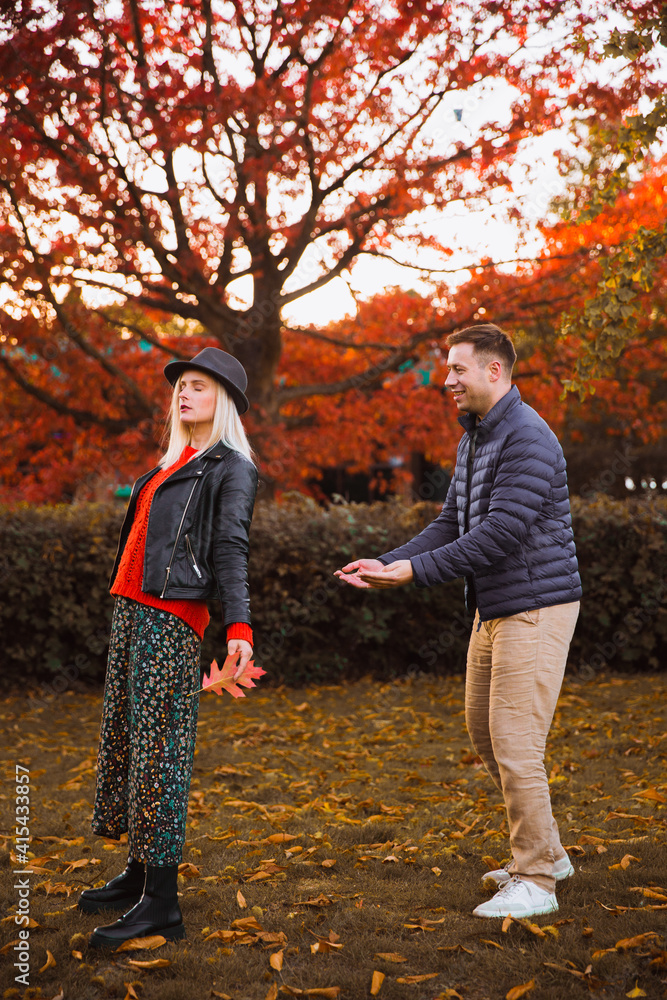 Obraz premium Man and woman. Autumn. Park. A man catches a falling woman