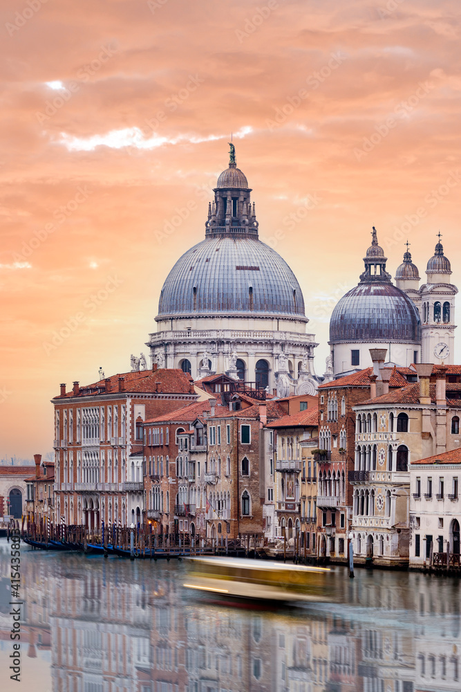 Fototapeta premium Stunning view of the Venice skyline with the Grand Canal and Basilica Santa Maria Della Salute in the distance during a dramatic sunrise. Picture taken from Ponte Dell’ Accademia.