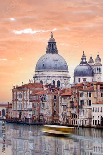 Stunning view of the Venice skyline with the Grand Canal and Basilica Santa Maria Della Salute in the distance during a dramatic sunrise. Picture taken from Ponte Dell’ Accademia. © Travel Wild