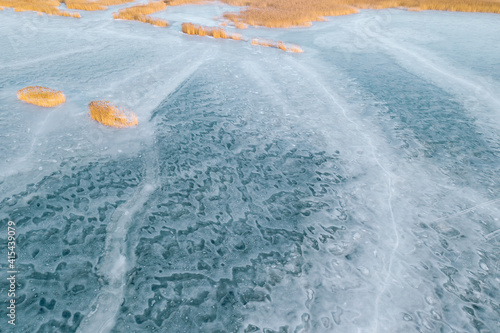 Aerial view of frozen lake. Ice from drone view. Winter landscape with clear smooth ice.
