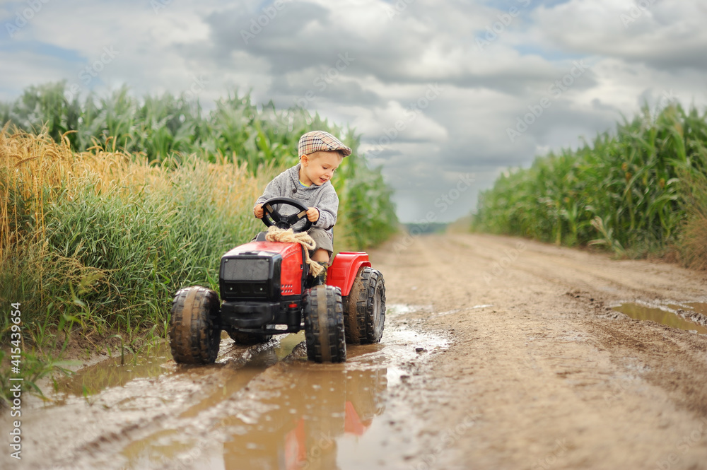 A farmer boy is driving a tractor through a corn field. A farmer boy is driving a tractor through a corn field.