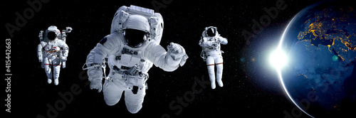 Fototapeta Astronaut spaceman do spacewalk while working for space station in outer space