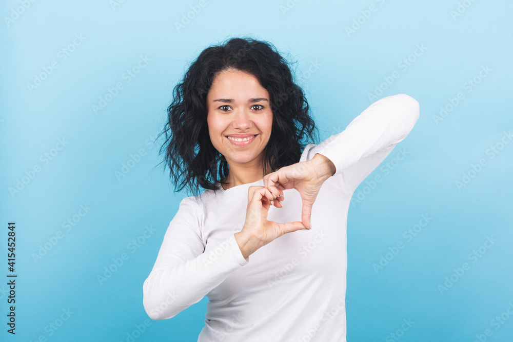 brunette girl makes a heart shape with her hands brunette girl makes a heart shape with her hands