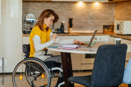 Young woman in wheelchair doing her homework © bernardbodo