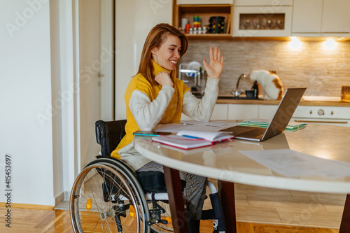 Young woman in wheelchair learning at home