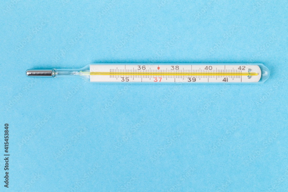 Macro shot of medical mercury thermometer. The principle of old and new. Outdated thermometer on blue background. Flat lay with a free space for text. Body temperature measuring device Macro shot of medical mercury thermometer. The principle of old and new. Outdated thermometer on blue background. Flat lay with a free space for text. Body temperature measuring device