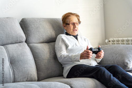 Cheerful senior woman playing video game