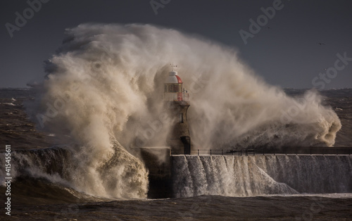 Giant waves batter the 15metre tall lighthouse which guards the south pier at the mouth of the Tyne at South Shields, England photo